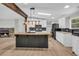 Open kitchen featuring a center island, stainless appliances, tile backsplash, and wood look floors at 6235 Akins Way, Cumming, GA 30041