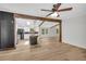 View of the open living space with beamed ceilings, a kitchen island, and wood-look flooring at 6235 Akins Way, Cumming, GA 30041