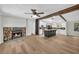 Open-concept living room with wood-burning fireplace, light floors, and a view into the kitchen at 6235 Akins Way, Cumming, GA 30041