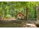 Outbuilding with a door and wooden fence in a lush backyard at 6235 Akins Way, Cumming, GA 30041