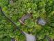 Aerial view of a brick home nestled amongst the trees, on a wooded lot at 630 Buttercup Trce, Johns Creek, GA 30022