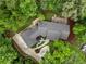 Aerial view of a brick home nestled amongst the trees, with a stone patio and driveway at 630 Buttercup Trce, Johns Creek, GA 30022