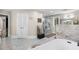 Bright bathroom featuring a shower stall, soaking tub, and white marble countertops at 630 Buttercup Trce, Johns Creek, GA 30022