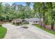 Charming one story brick home featuring a covered front porch, manicured landscaping and circular driveway at 630 Buttercup Trce, Johns Creek, GA 30022