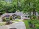 Charming brick home with lush landscaping, a circular driveway and a covered front porch at 630 Buttercup Trce, Johns Creek, GA 30022