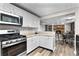 This kitchen features stainless steel appliances, white cabinets, and stone countertops at 630 Buttercup Trce, Johns Creek, GA 30022
