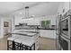 Modern kitchen with white cabinetry, black granite countertops, stainless steel appliances, and central island at 630 Buttercup Trce, Johns Creek, GA 30022