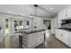 Large kitchen featuring a center island with seating, granite countertops, and access to the outdoor patio at 630 Buttercup Trce, Johns Creek, GA 30022