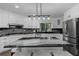 Modern white kitchen featuring stainless steel appliances, granite countertops, and a center island with barstool seating at 630 Buttercup Trce, Johns Creek, GA 30022