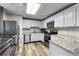 The kitchen features a refrigerator, oven, microwave and stone countertops at 630 Buttercup Trce, Johns Creek, GA 30022