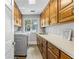 Well-organized laundry room with wooden cabinets, white countertops, a modern washer, and a dryer at 630 Buttercup Trce, Johns Creek, GA 30022