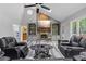 Comfortable living room with stone fireplace, built-in bookshelves, and a large screen television at 630 Buttercup Trce, Johns Creek, GA 30022