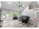 Spacious living room with vaulted ceilings, skylights, a ceiling fan, and large windows overlooking a wooded lot at 630 Buttercup Trce, Johns Creek, GA 30022