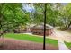 Brick home featuring a wooden deck, lush lawn and mature trees, perfect for enjoying the outdoors at 630 Buttercup Trce, Johns Creek, GA 30022