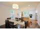 Elegant dining area connected to a modern kitchen, featuring a long dark table set for six at 1454 Rome Nw Dr, Atlanta, GA 30314