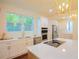 Bright kitchen boasts white cabinets, stainless steel appliances, quartz countertops, and a center island at 1454 Rome Nw Dr, Atlanta, GA 30314