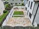 Aerial view of a fenced backyard, stone patio, grass area, and white pergola structure at 2111 Nelms Pointe Lndg, Lawrenceville, GA 30043