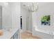 Bright bathroom featuring double sinks, soaking tub, shower and chandelier lighting at 2111 Nelms Pointe Lndg, Lawrenceville, GA 30043