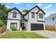 Two story home featuring a two-car garage, black trim, and manicured front lawn at 2111 Nelms Pointe Lndg, Lawrenceville, GA 30043
