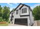 Two story home featuring a two-car garage, black trim, and manicured front lawn at 2111 Nelms Pointe Lndg, Lawrenceville, GA 30043