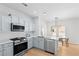 Modern kitchen features stainless steel appliances, light grey cabinetry, and a dining area with stylish lighting at 2111 Nelms Pointe Lndg, Lawrenceville, GA 30043