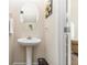 Chic powder room featuring a pedestal sink, decorative mirror, and neutral color palette at 2149 Apple Orchard Way, Austell, GA 30168