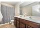 Bathroom with a double sink vanity, decorative mirror, and shower with patterned curtain at 2149 Apple Orchard Way, Austell, GA 30168