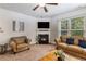 Cozy living room with a fireplace, plush seating, and a large window with outdoor views at 2149 Apple Orchard Way, Austell, GA 30168
