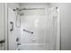 Bathroom with white tiles, showerhead, grab bar, and shower curtain providing a clean and accessible space at 2325 Walnut Grove Way, Suwanee, GA 30024