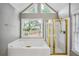 Bright bathroom features a large tub, glass shower, and natural light from multiple windows at 2325 Walnut Grove Way, Suwanee, GA 30024