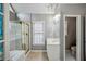 Bathroom with a large tub, shower, chandelier, white vanity, and tiled floors at 2325 Walnut Grove Way, Suwanee, GA 30024