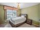 Bedroom with a queen-sized bed, beige carpet, and plenty of natural light from the large window at 2325 Walnut Grove Way, Suwanee, GA 30024