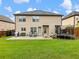 Large backyard with a well-maintained lawn, patio seating, and a trampoline perfect for outdoor relaxation at 2490 Tack Hill Ct, Dacula, GA 30019