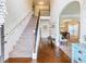Bright foyer featuring hardwood floors, a staircase, and a view into the dining room with a coffered ceiling at 2490 Tack Hill Ct, Dacula, GA 30019