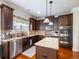 Well-lit kitchen with stainless steel appliances, granite countertops, an island and dark wood cabinetry at 2490 Tack Hill Ct, Dacula, GA 30019