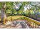 Wood deck and fenced backyard with a lush lawn, mature trees, and natural sunlight creates a private retreat at 2876 Randall St, East Point, GA 30344