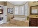 Elegant bathroom featuring a soaking tub with shutters and custom tiled surround at 3902 Butterstream Way, Kennesaw, GA 30144