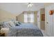 Bright bedroom featuring a bed with blue patterned bedding, a ceiling fan, and natural light at 3902 Butterstream Way, Kennesaw, GA 30144