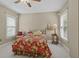 Warm bedroom featuring natural light, a cozy bed with a red floral comforter, and neutral walls at 3902 Butterstream Way, Kennesaw, GA 30144