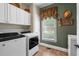 Laundry room featuring front load washer and dryer, window, and white cabinets at 3902 Butterstream Way, Kennesaw, GA 30144
