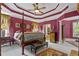 Primary bedroom featuring a tray ceiling, hardwood floors, a ceiling fan, and a four poster bed at 3902 Butterstream Way, Kennesaw, GA 30144