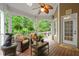 Cozy covered patio featuring comfortable seating, a ceiling fan, and a serene view of the wooded backyard at 3902 Butterstream Way, Kennesaw, GA 30144
