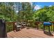 Inviting deck with wood railing, chairs, grill and a lovely treed view provides an ideal outdoor living space at 803 Baugh Springs Ln, Lawrenceville, GA 30044