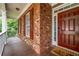 Welcoming front porch with brick facade, wood flooring, and white railings offer charming curb appeal at 803 Baugh Springs Ln, Lawrenceville, GA 30044