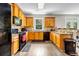 Kitchen featuring wood cabinets, granite countertops, tile backsplash, and black appliances at 803 Baugh Springs Ln, Lawrenceville, GA 30044