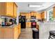 Bright kitchen with wood cabinets, granite countertops, black appliances, and wood floors at 803 Baugh Springs Ln, Lawrenceville, GA 30044