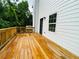 This angle features a wide, light-colored wooden back deck attached to the house with wood railings at 1540 Ox Bridge Ct, Lawrenceville, GA 30043