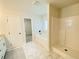 Well-lit bathroom featuring a separate tub and shower, and marble-look tile at 1540 Ox Bridge Ct, Lawrenceville, GA 30043