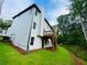 This exterior shows a newly constructed two-story home with a small deck, back yard and mulched flower beds at 1540 Ox Bridge Ct, Lawrenceville, GA 30043