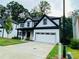 Charming two-story home boasts a two-car garage, black trim, and lush landscaping at 1540 Ox Bridge Ct, Lawrenceville, GA 30043
